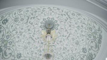 Decorative ceiling in a form of a dome with blue floral pattern. Scene. Hanging small chandelier, bottom view. video