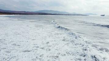 Powerful waves forming, breaking on the shore and splashing with white foam video