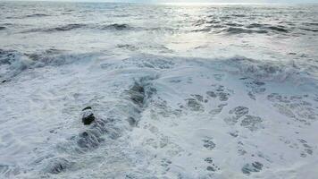 Powerful waves forming, breaking on the shore and splashing with white foam video