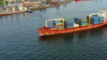 antenne visie. een lading houder schip langzaam het zeilen in de donker wateren video