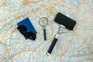 Travel accessories set on the map background smart, passport and selfish stick. Top view point. photo