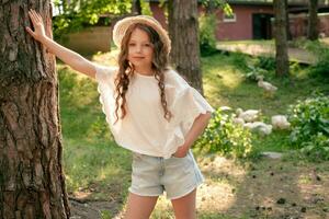 preadolescente niña propensión de alto árbol maletero en verde patio de país casa foto