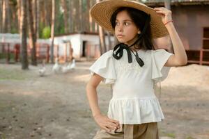 Closeup portrait of preteen brunette in courtyard of country house in pine forest photo