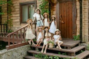 Preteen girls posing together on doorstep of rural cottage on summer day photo