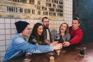 Group of young beautiful friends watching TV and cheering for th photo