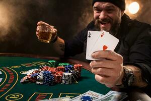 Bearded man showing poker cards on black background photo
