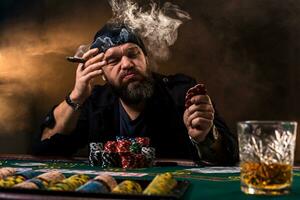 Man is playing poker with a cigar and a whiskey. A man winning all the chips on the table with thick cigarette smoke. photo