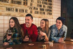 acecho televisión en pub. contento joven amigos son aplausos para equipo un foto