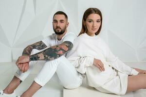 Portrait of a beautiful young couple in love posing at studio over white background. photo