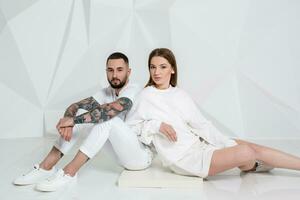 Portrait of a beautiful young couple in love posing at studio over white background. photo