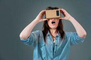 Woman using a new virtual reality headset on grey background photo