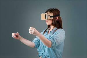 Woman using a new virtual reality headset on grey background photo