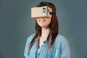 Woman using a new virtual reality headset on grey background photo