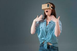 Woman using a new virtual reality headset on grey background photo