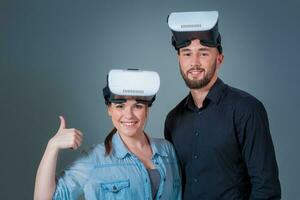Excited young man and woman having fun with a VR glasses photo
