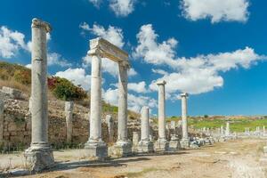Agora of the ancient city of Perge in clear sunny weather. Against the background of a blue sky with clouds. photo