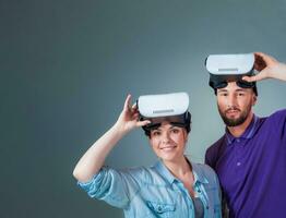 Excited young man and woman having fun with a VR glasses photo