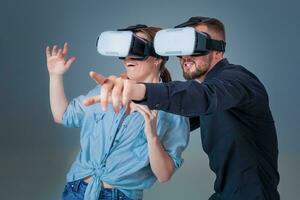 Excited young man and woman having fun with a VR glasses photo