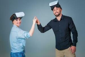 Excited young man and woman having fun with a VR glasses photo