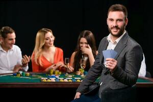 Poker players in casino with cards and chips on black background photo