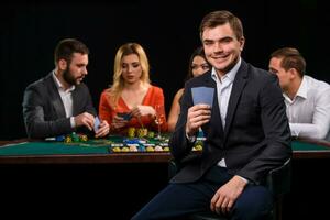 Young people playing poker at the table. Casino photo