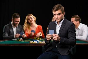 Young people playing poker at the table. Casino photo