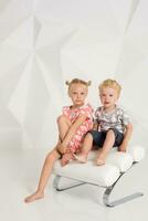 Portrait of the sister and its little brother at white studio photo
