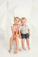 Portrait of the sister and its little brother at white studio photo