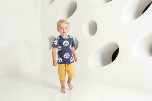 little boy in a t-shirt and shorts on a white background photo