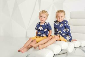 Portrait of the sister and its little brother at white studio photo