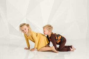 hermano y hermana jugando y sonriente en un blanco estudio foto