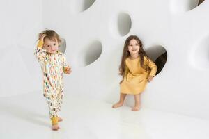 Children sisters play together on white background photo