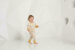 Year-old child standing near white wall in studio photo