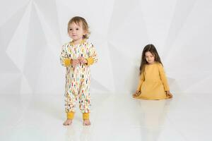 Children sisters play together on white background photo