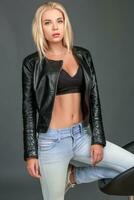 young blond woman in a black leather jacket photo