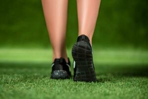His feet beautiful woman in the shoes are on a grass. Close up photo