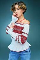 Portrait of charming young lady with short hair in embroide photo