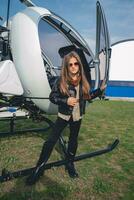 Full length portrait of tween girl in sunglasses near open helicopter photo