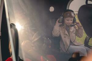 Tween girl putting on headset on pilot seat in helicopter photo