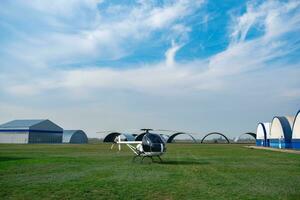 Ultralight white helicopter on green flying field in aeroclub photo