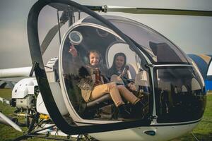 Cheerful tween girl pointing to sky from helicopter cockpit photo