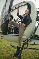 Preteen girl in mirrored sunglasses looking up to sky from steps of helicopter photo