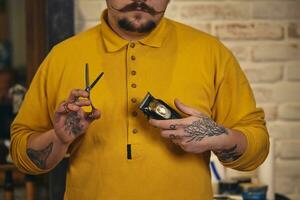 elegante Barbero hombre con peluquería herramientas en su manos preparar para trabajo foto