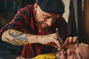 Client during beard shaving in barber shop photo