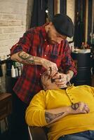 Client during beard shaving in barber shop photo