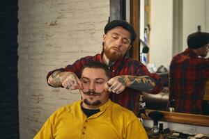Client during beard shaving in barber shop photo
