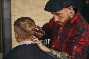 caucásico chico consiguiendo Corte de pelo en barbería interior foto