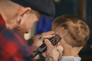 caucásico chico consiguiendo Corte de pelo en barbería interior foto