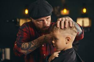 caucásico chico consiguiendo Corte de pelo en barbería interior foto