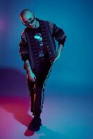 Studio shot of a young tattoed bald man posing against a colorful background. 90s style. photo